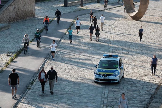 Agentes de la policía local vigilan en Sevilla el cumplimiento de las normas en el primer fin de semana para hacer deporte