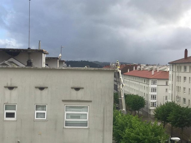 Bombero en el tejado de un edificio del barrio de Fontiñas, en Santiago, tras la caída de un tejado por el temporal