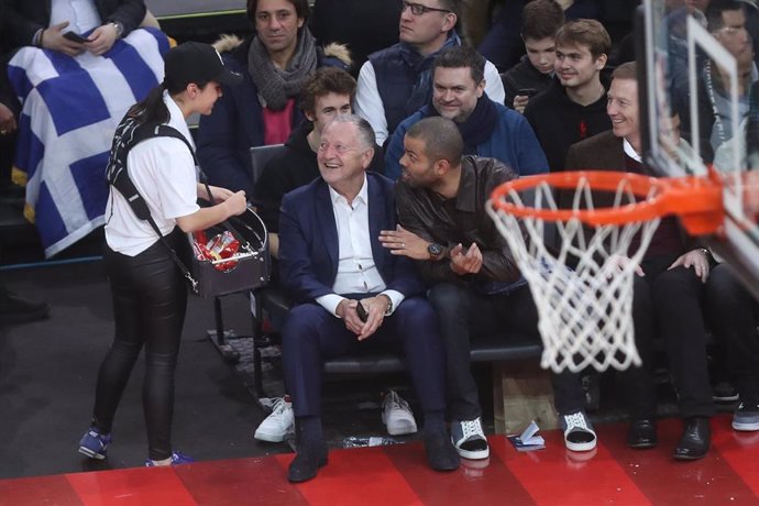 Tony Parker charla con Jean Michel Aulas durane el partido de la NBA en París entre los Bucks y los Hornets