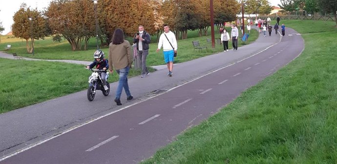 Un niño pasea en su moto de juguete por el parque de los Pericones