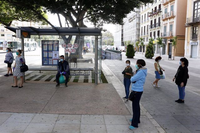 Varias personas esperando el autobús guardan la distancia de seguridad, durante la fase 0 de la desescalada del Gobierno en el inicio de la semana 8 del estado de alarma. En Málaga(Andalucía, España), a 04 de mayo de 2020.