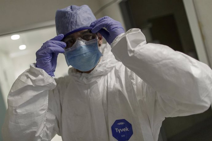 Un trabajador sanitario se coloca las gafas protectoras para trabajar en la Unidad de Cuidados Intensivos del Hospital Infanta Sofía en San Sebastián de los Reyes (Madrid)  