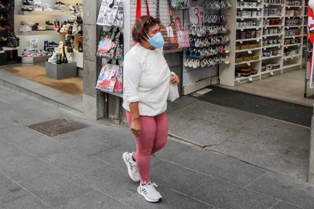 Una mujer lleva mascarilla para protegerse del coronavirus en una calle de Madrid
