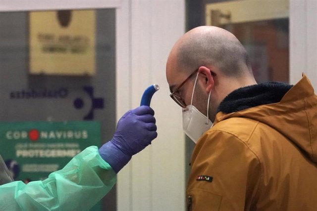 Un sanitario toma la temperatura a uno de los paciente diagnosticados con COVID-19 a los que no se le realizó previamente test antes de realizar el cribado, en el centro de centro de salud de Osakidetza del casco viejo de Bilbao.