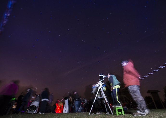 Personas observando una lluvia de estrellas (Imagen de archivo)