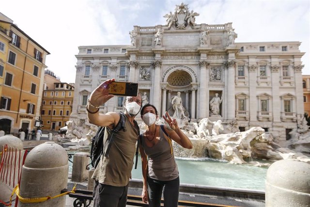Personas haciendo un selfie en la Fontana de Trevi