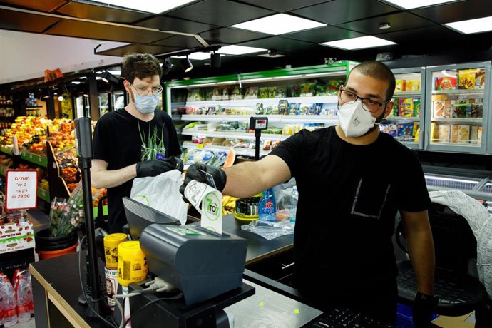 Dos trabajadores de un supermercado local de Tel Aviv, Israel.