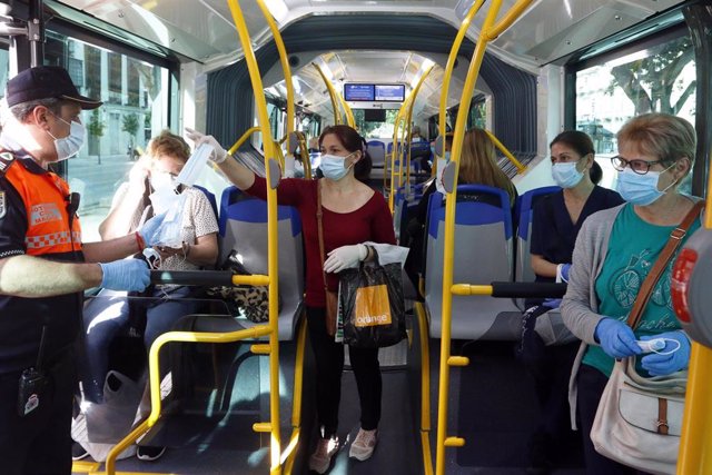 Miembros de protección civil de Málaga entregan mascarillas a los pasajeros de autobuses, durante la fase 0 de la desescalada del Gobierno en el inicio de la semana 8 del estado de alarma. En Málaga(Andalucía, España), a 04 de mayo de 2020.