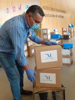 Una persona carga en la Diputación de Málaga cajas de mascarillas para distribuir por la provincia de Málaga