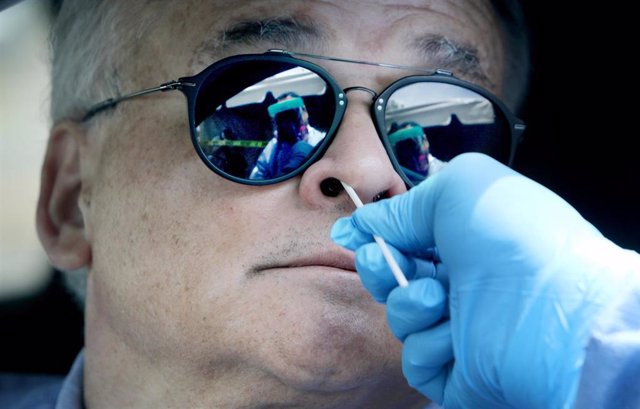 06 May 2020, US, Clearwater: A medic takes a swab from a man inside his car for a Coronavirus (Covid-19) test at the Community Health Center of Pinellas. Photo: Douglas R. Clifford/Tampa Bay Times via ZUMA Wire/dpa