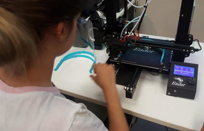 Una chica fabrica una pantalla protectora ante el covid-19