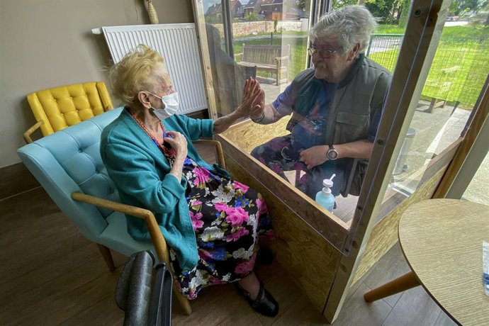 Una mujer en una residencia de ancianos recibe una visita en Bélgica
