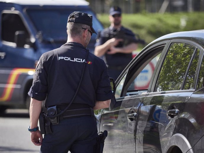 Un policía nacional interroga al conductor de un vehículo en un control por el estado de alarma