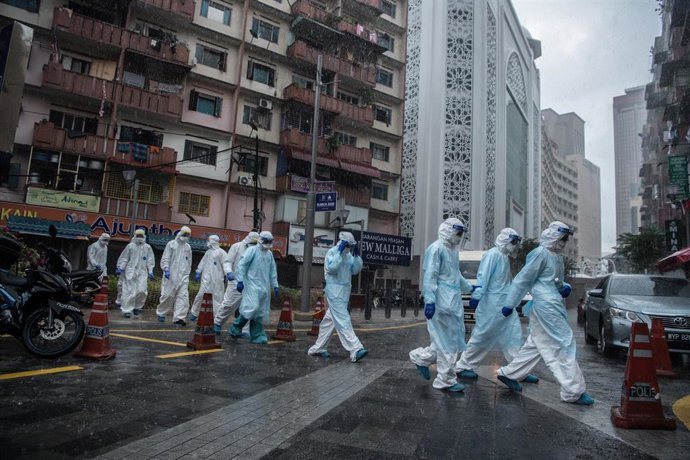 Trabajadores del Ministerio de Sanidad saliendo de un edifcio de Johannesburgo tras hacer pruebas de coronavirus a los vecinos