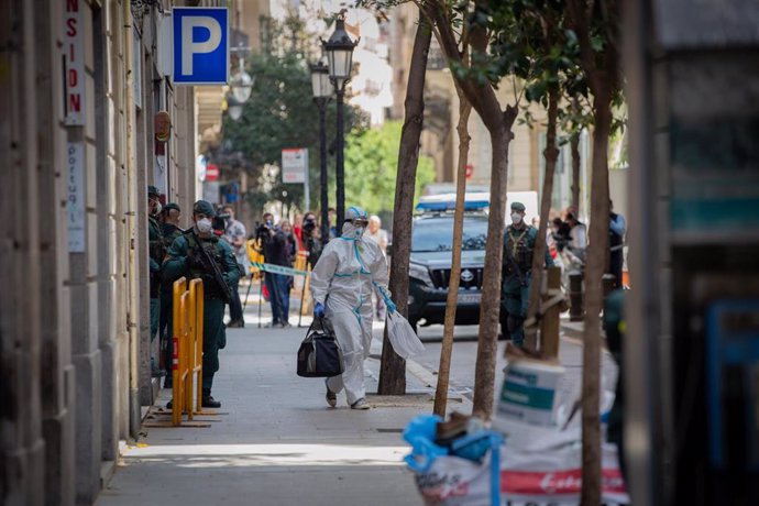 Agentes de la Guardia Civil totalmente protegidos salen de un domicilio de la calle de Josep Anselm Clavé en el distrito de Ciutat Vella de Barcelona donde han detenido a un presunto yihadista que buscaba objetivos bajo el estado de alarma por la crisis