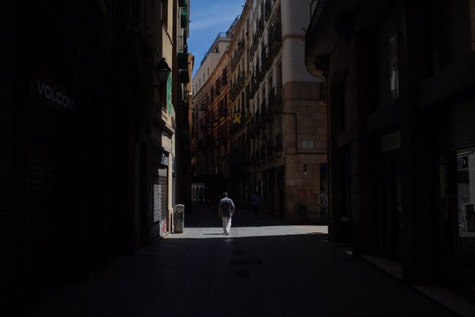 Un home passeja per un carrer durant el tercer dia de desconfinamiento, a Barcelona/Catalunya (Espanya) a 4 de maig de 2020.