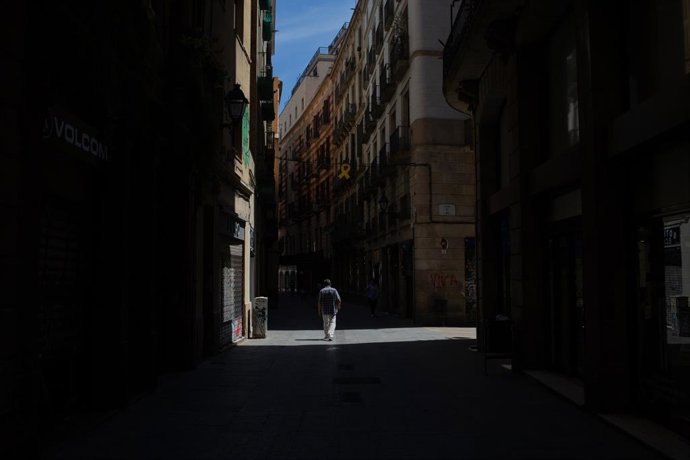 Un home passeja per un carrer durant el tercer dia de desconfinamiento, a Barcelona/Catalunya (Espanya) a 4 de maig de 2020.