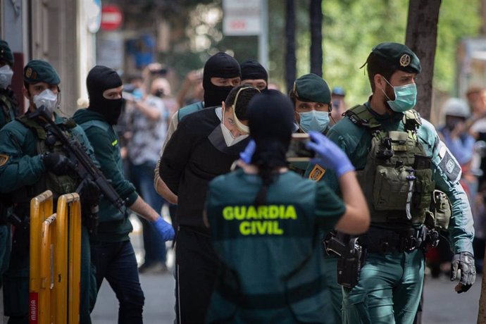 Agentes de la Guardia Civil totalmente protegidos detienen al presunto yihadista en un domicilio de la calle de Josep Anselm Clavé en el distrito de Ciutat Vella de Barcelona por supuestamente buscar objetivos bajo el estado de alarma por la crisis del 