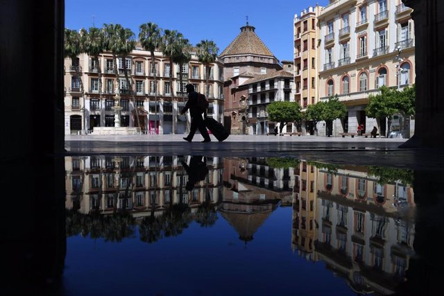 Una persona camina por la plaza de la Constitución de Málaga totalmente vacía por el decreto de Alarma antela existencia del virus COVID-19.Málaga a 25 de abril del 2020