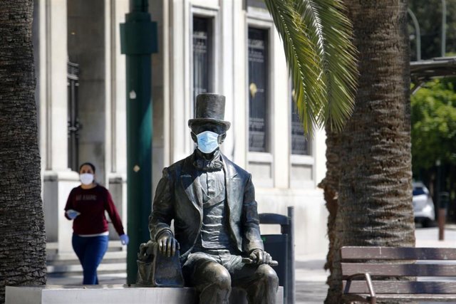 Estatua en Málaga del autor del "Patito Feo" Hans Christian Andersen con una mascarilla ante el virus del COVID-19. 