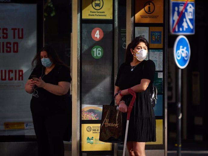 Una mujer con mascarilla para protegerse del coronavirus espera al autobús durante el día 54 del estado de alarma en Pamplona / Navarra (España), a 7 de mayo de 2020.