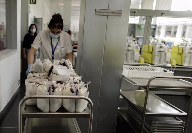 Una sanitaria transporta las bolsas de transfusión de sangre para pesarlas y posteriormente introducirlas en la centrifugadora para separar sus componentes en el Centro de Transfusión de la Comunidad de Madrid