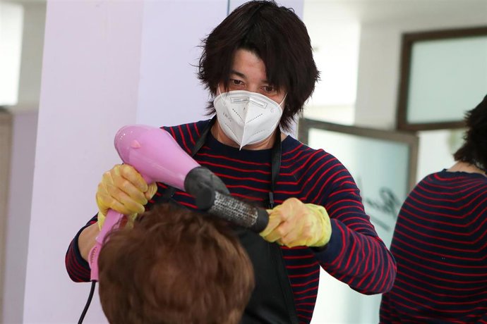 Maite Valero, propietaria de un salón de peluquería en Paterna, Valencia, atiende a una cliente durante el 55 día desde que el Gobierno declaró el estado de alarma en España para combatir el coronavirus COVID-19. A 8 de mayo de 2020, en Valencia, España