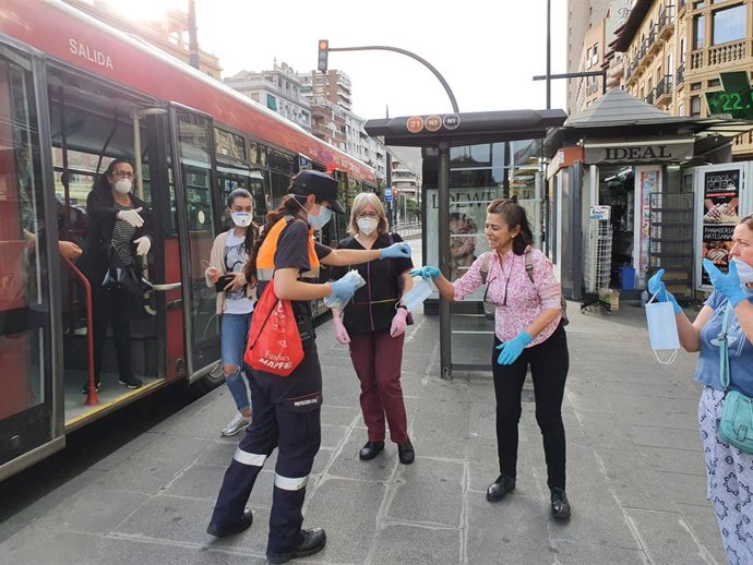 Imagen del reparto de mascarillas por una voluntaria de Protección Civil en Granada.