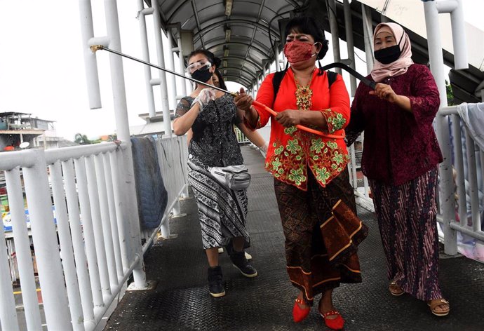 Un grupo de mujeres colaboran en las tareas de desinfección de una zona de la ciudad de Yakarta, Indonesia.