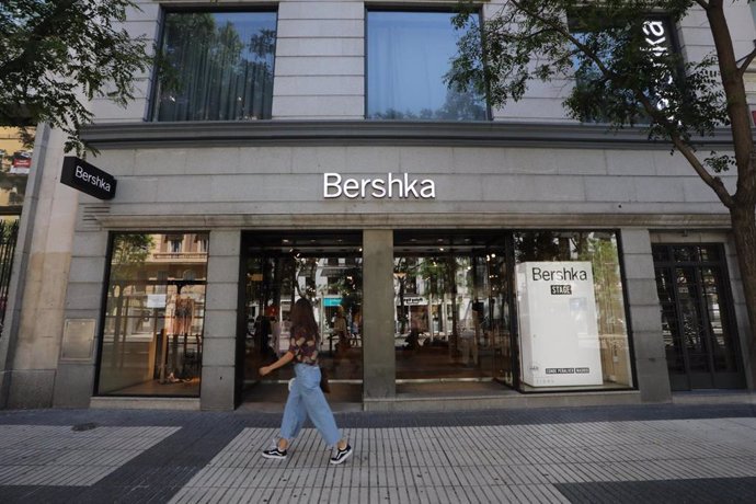 Una joven pasa delante de una tienda de Bershka, propiedad de Inditex.