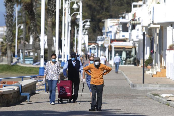 Personas mayores recorren el paseo marítimo por la zona de La Malagueta en las horas asignadas a ellos, en el día en que el Gobierno permite salir a hacer deporte de forma individual y pasear con otra persona con la que se conviva, a determinadas horas,