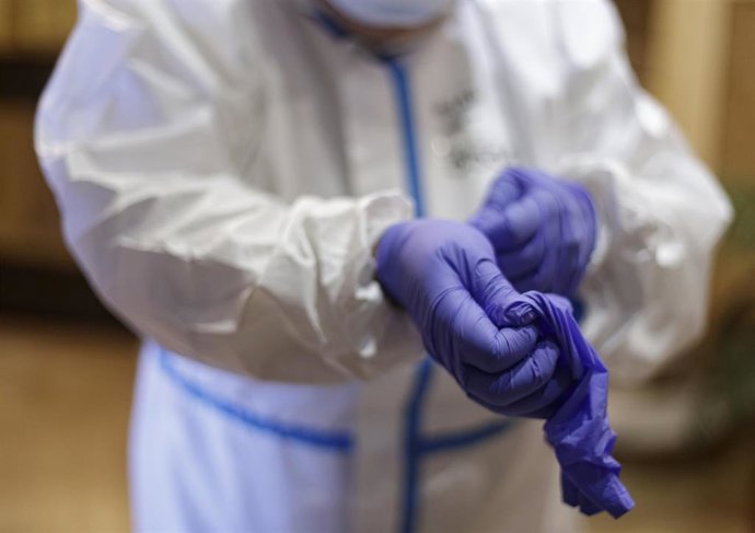 Personal sanitario de una residencia de ancianos se coloca el material de protección.
