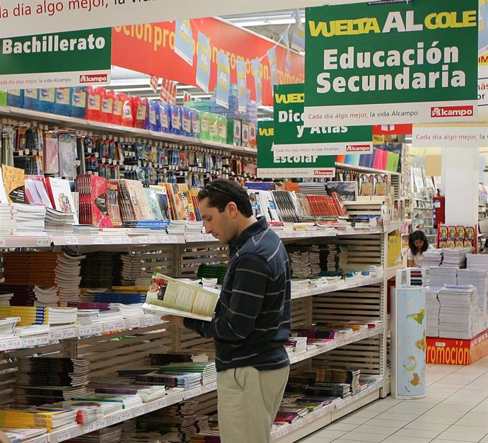 Un hombre ojea libros de texto en un centro comercial.