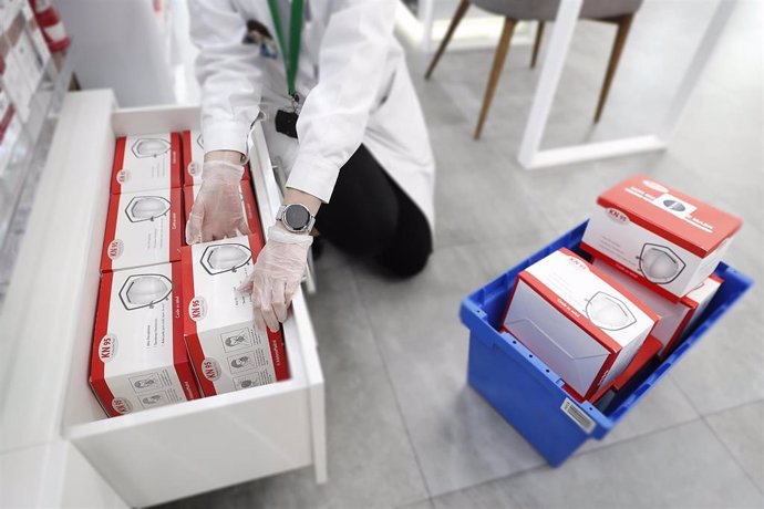 Una farmacéutica coloca cajas que contienen parte de los siete millones de mascarillas FFP2 que la Comunidad de Madrid 