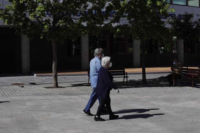 Dos personas pasean por una calle del municipio de Las Rozas (Madrid).