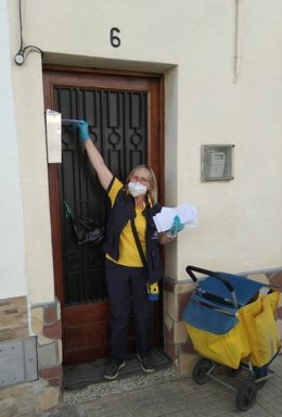 Una cartera de correos reparte mascarillas adquiridas por el Ayuntamiento de Parets del Valls (Barcelona) para mayores de 60 años