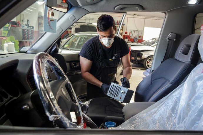Imagen de un vehículo siendo desinfectado en un taller. 