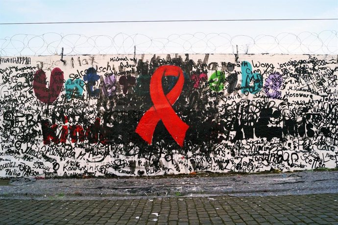 Crespón rojo pintando en una pared, un gesto simbólico para reivindicar el Día Mundial de la lucha contra el VIH.