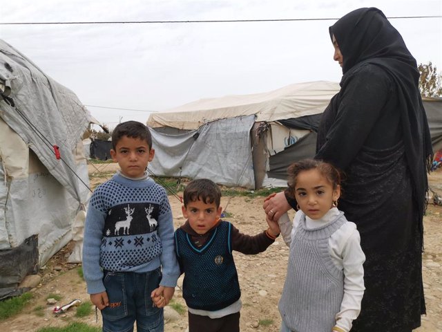 Una mujer desplazada y sus hijos en Irak