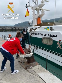La Guardia Civil entrega marisco requisado a un pesquero en Orio a la Cruz Roja