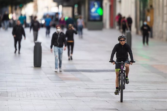 Varias personas realizan deporte en bicicleta por la Calle Preciados de Madrid 