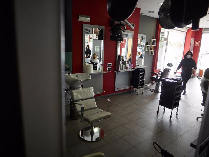Esther Alvarado, propietaria de la peluquería, entra en su establecimiento durante la apertura de la peluquería por primera vez desde que se decretara el Estado de Alarma en España con motivo del coronavirus