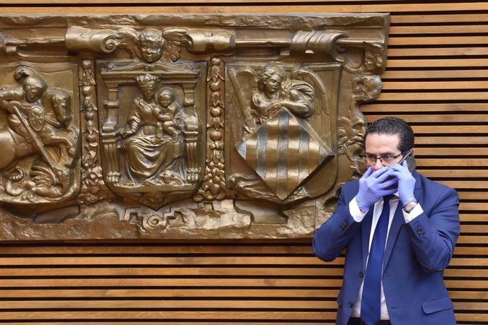 Uno de los diputados hace una llamada con guantes en Les Corts