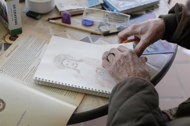 Una anciana realiza un dibujo en el interior de la Residencia de Mayores Jesús del Buen Amor donde los trabajadores sanitarios trabajan para cuidar a los residentes que allí viven en plena pandemia del Covid-19
