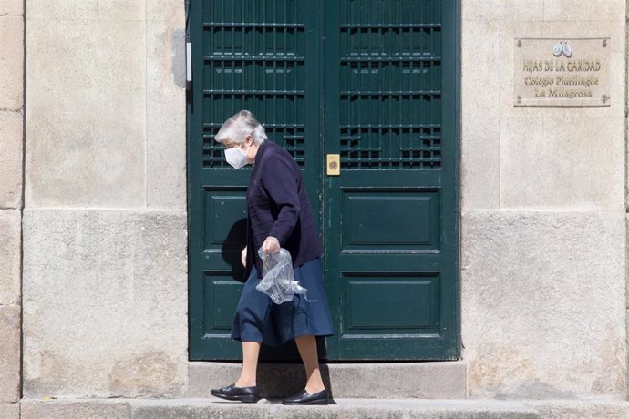Una mujer con mascarilla pasea por la calle, en Lugo/Galicia (España) a 3 de mayo de 2020.