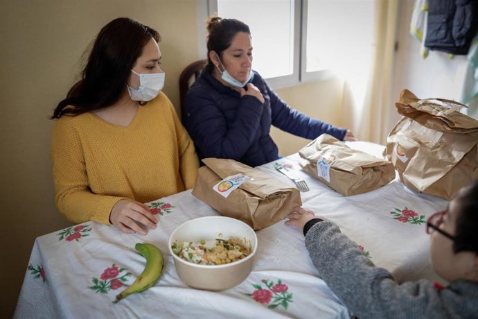 Dos mujeres y un niño durante la comida en su casa del barrio madrileño de Carabanchel prueban el menú de la ONG del chef José Andrés, que reparte en Madrid a las familias más necesitadas