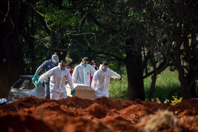 Un grupo de trabajadores se prepara para enterrar a una víctima del nuevo coronavirus en el cementerio de Vila Formosa, en Sao Paulo, sur de Brasil.