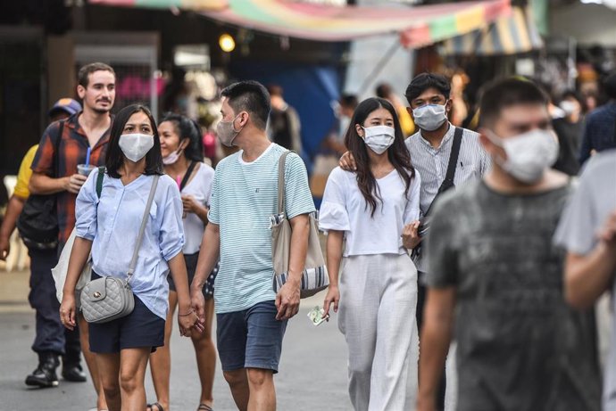 Parejas con mascarilla en un mercado de Bangkok