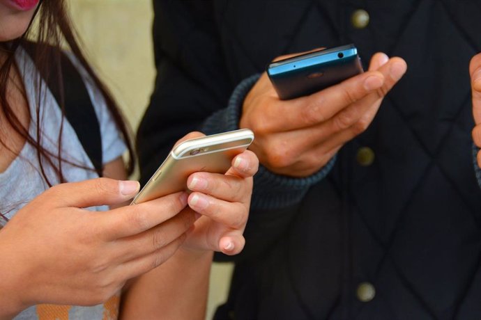 Chateando. Gente con el móvi. Usando el móvil. Jóvenes con smartphone