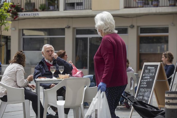 Personas consumiendo en los veladores de un bar abierto durante el segundo día de la fase 1 del plan de desescalada 